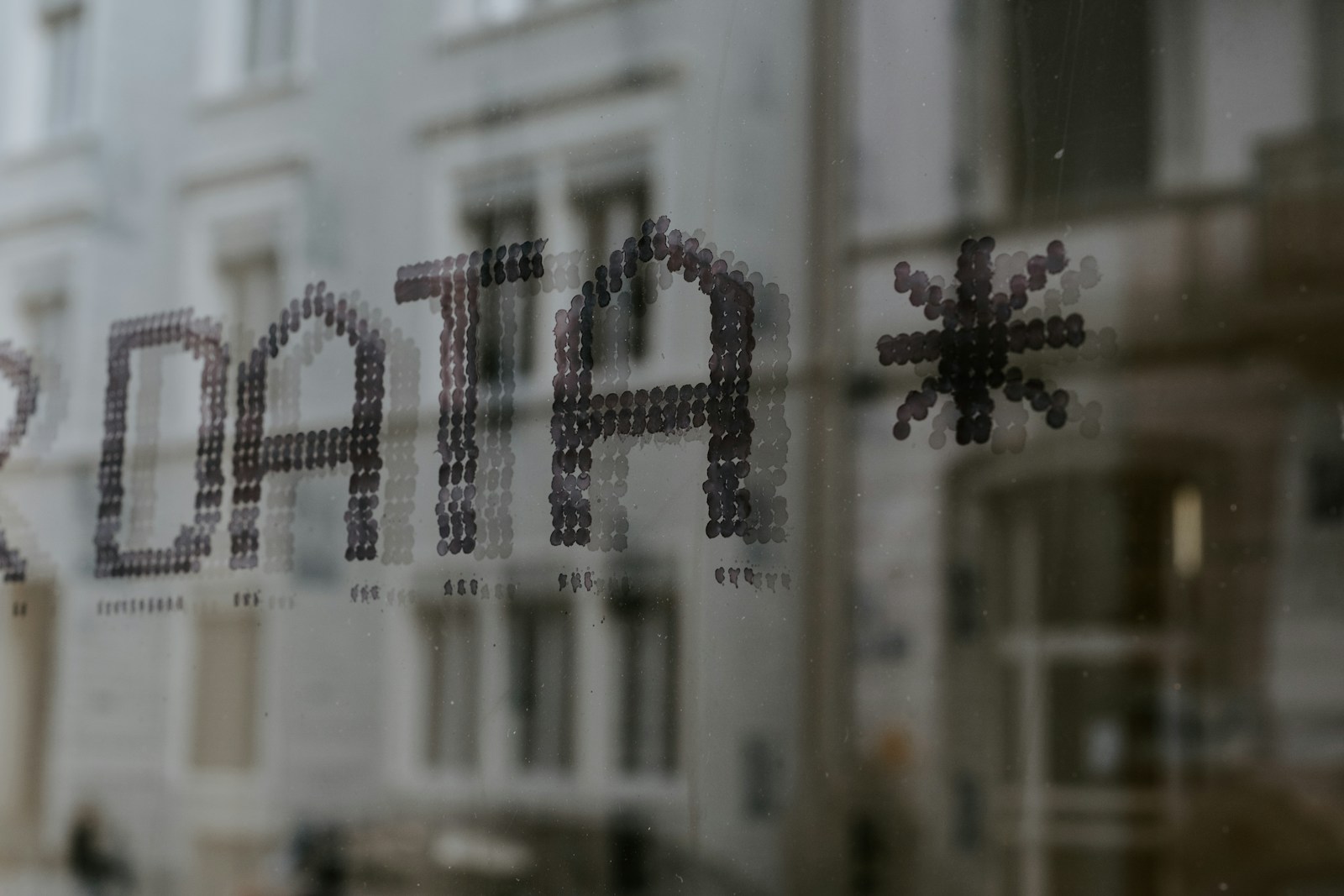 Photo by Claudio Schwarz a close up of a window with a building in the background