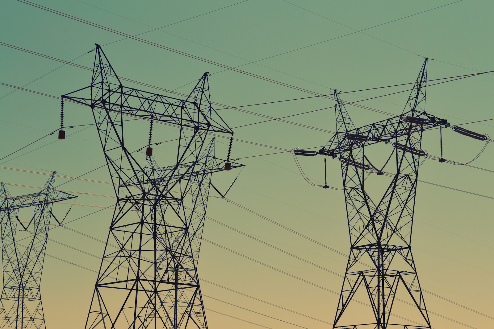 Photo by Fré Sonneveld black transmission towers under green sky Energy Data Management